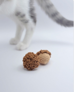 Crochet acorn toys with cat, showing pet toy use