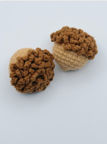 Handmade crochet acorn squishy toys, two pieces on white background